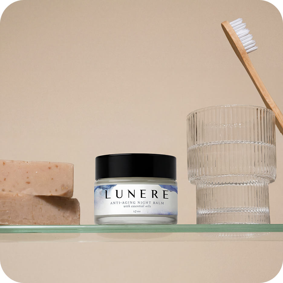 Lunere anti-aging night balm jar on a shelf with a glass container and soap bar.